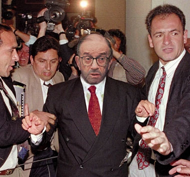 Above: Fed chief Alan Greenspan is led to a holding cell following his arrest for trashing a hotel room. It is his third such arrest in as many years.